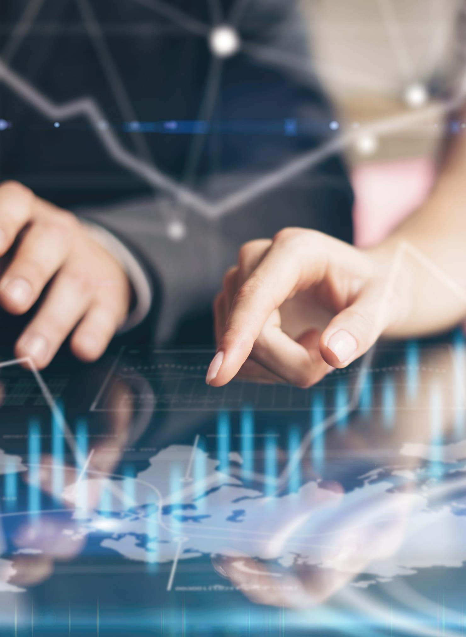 Hands working on a tablet under a chart overlay