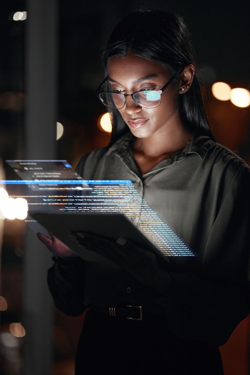 Woman reading a holographic tablet in a dim room